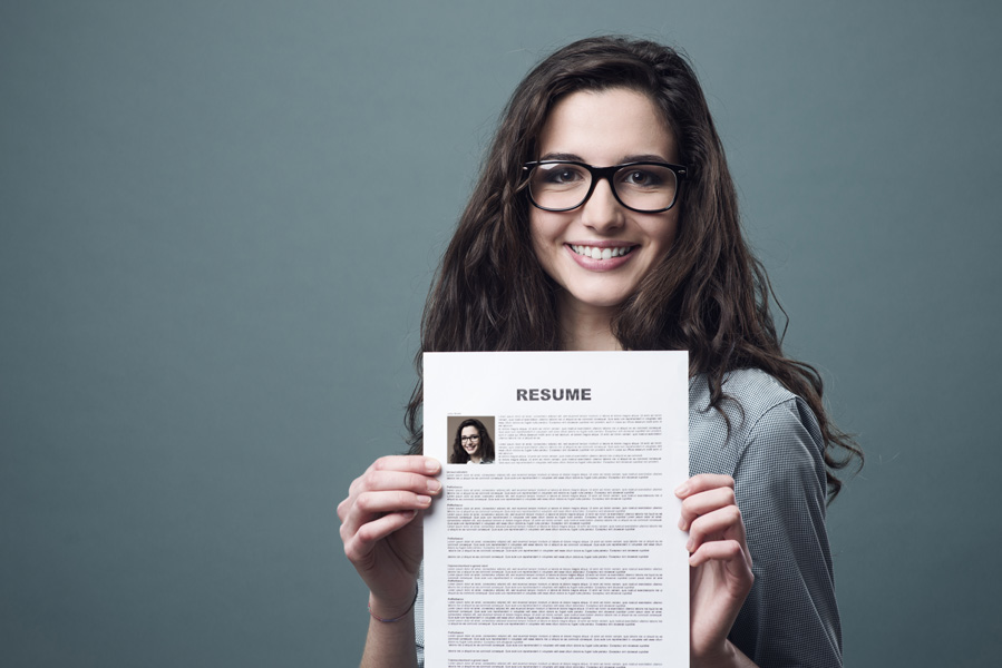 bigstock-Young-Woman-Holding-Her-Resume-83916842